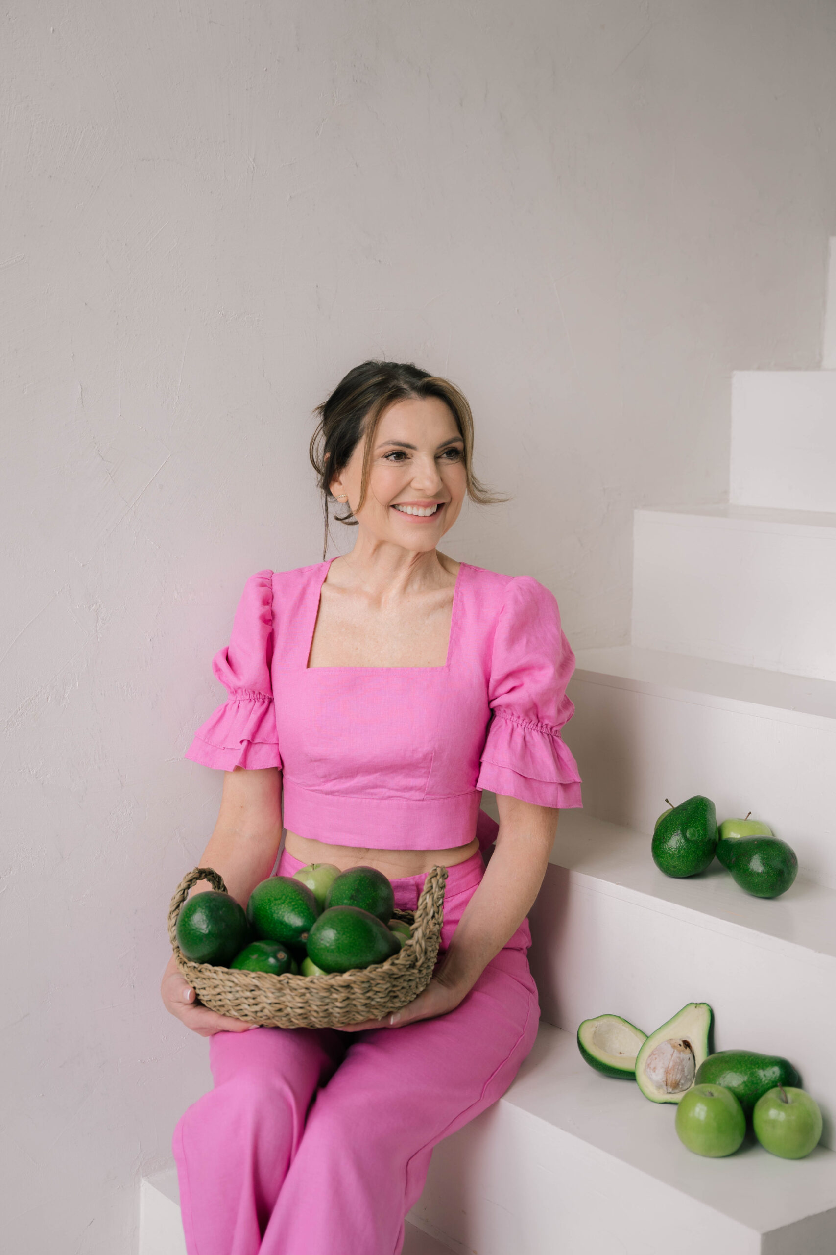 Een jonge vrouw op de achtergrond die kijkt naar een flesje water en blaadjes sla.