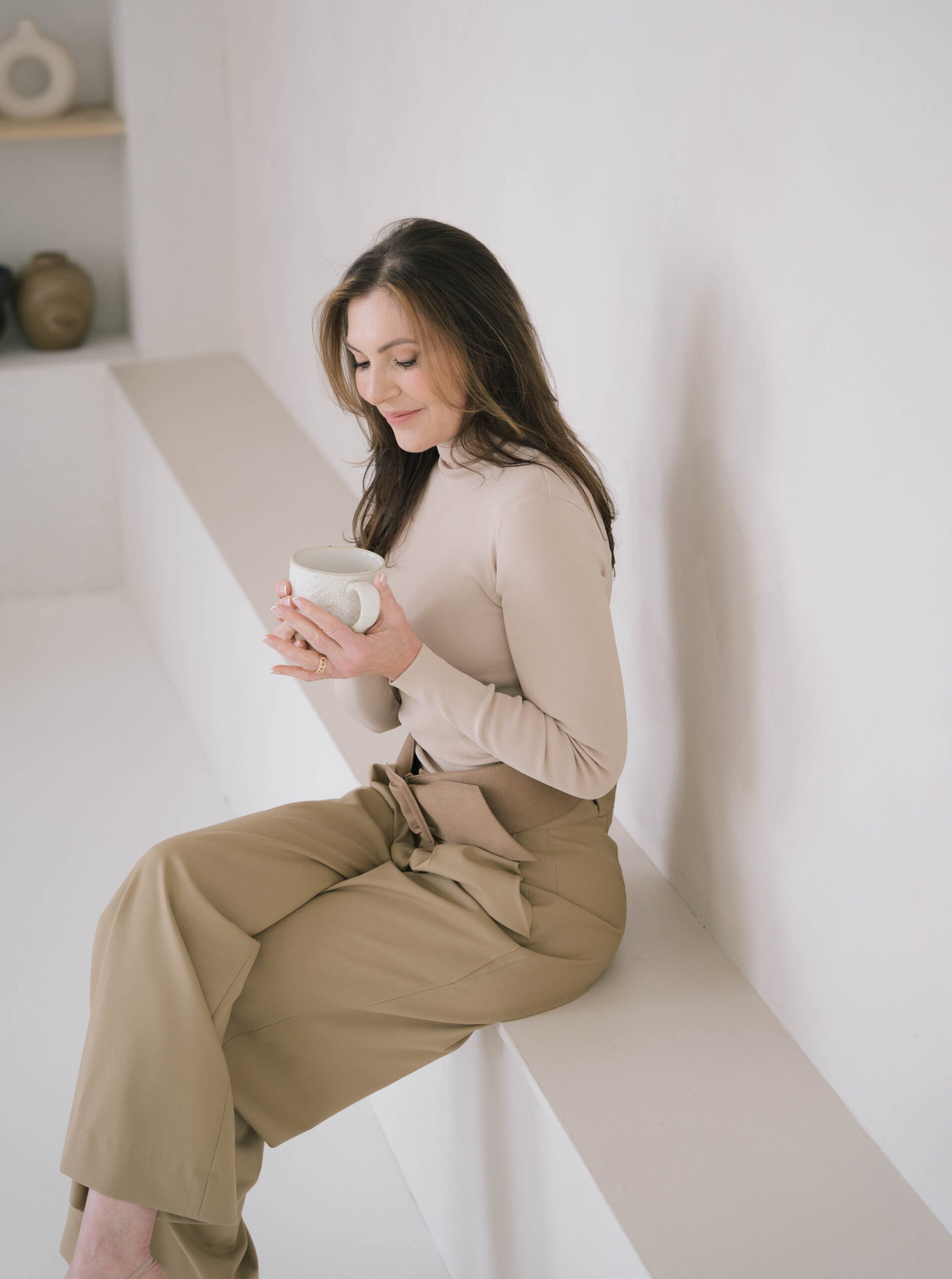 Marjena zittend op een bank en drink een kop thee