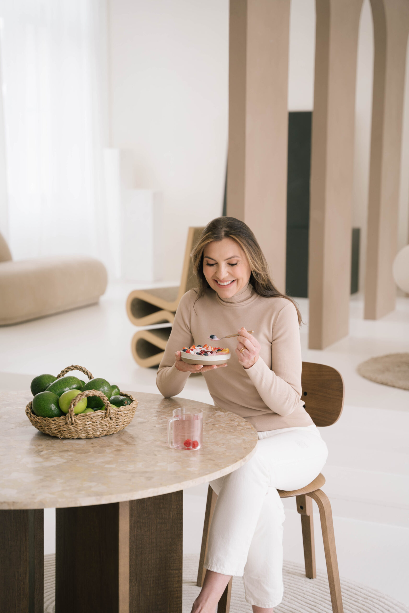 Marjena zit aan tafel en staat op het punt om yoghurt met fruit te eten