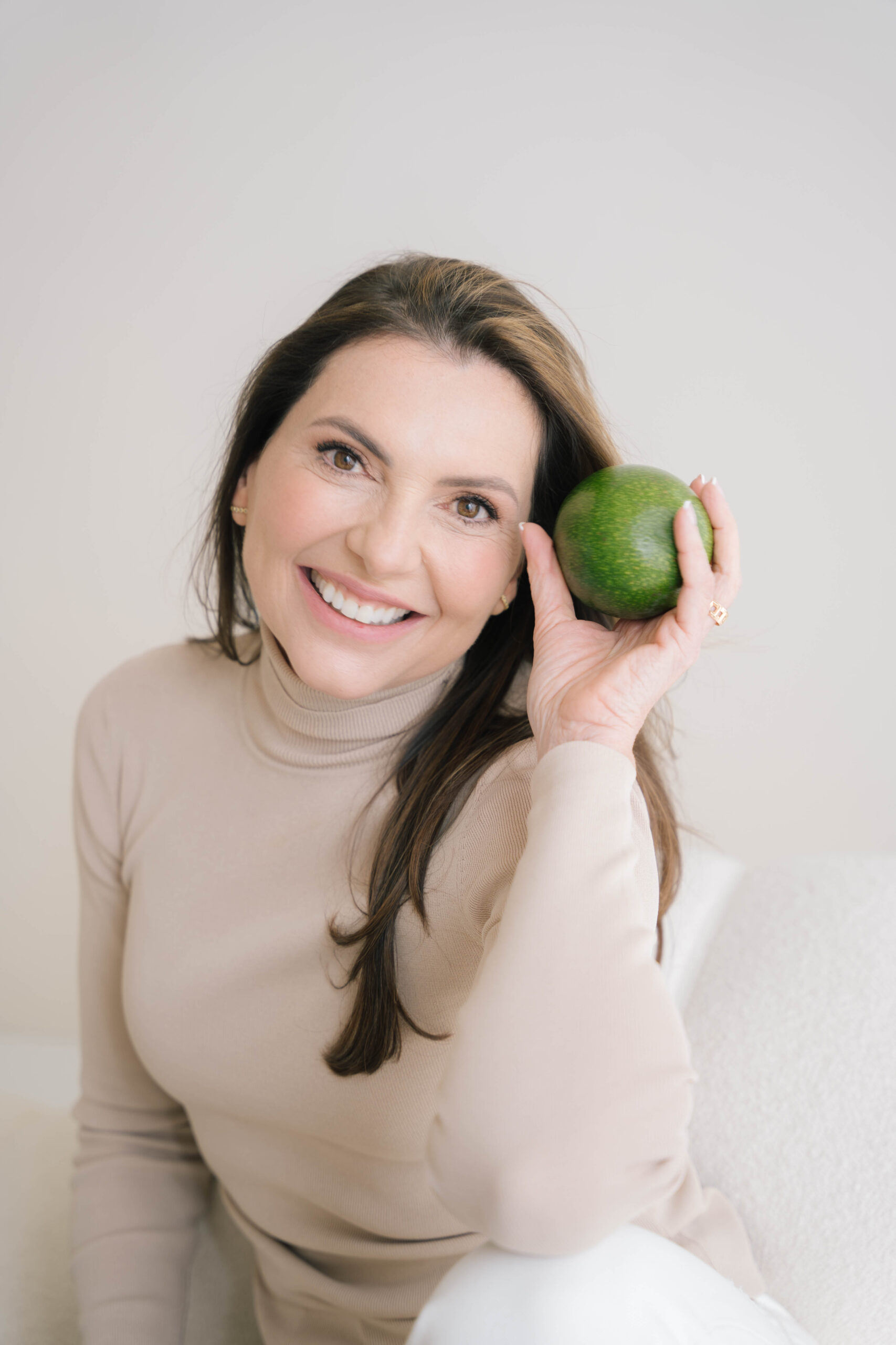 Marjena op het strand, kijkend in de camera, lachend. Ze heeft een groene jurk aan