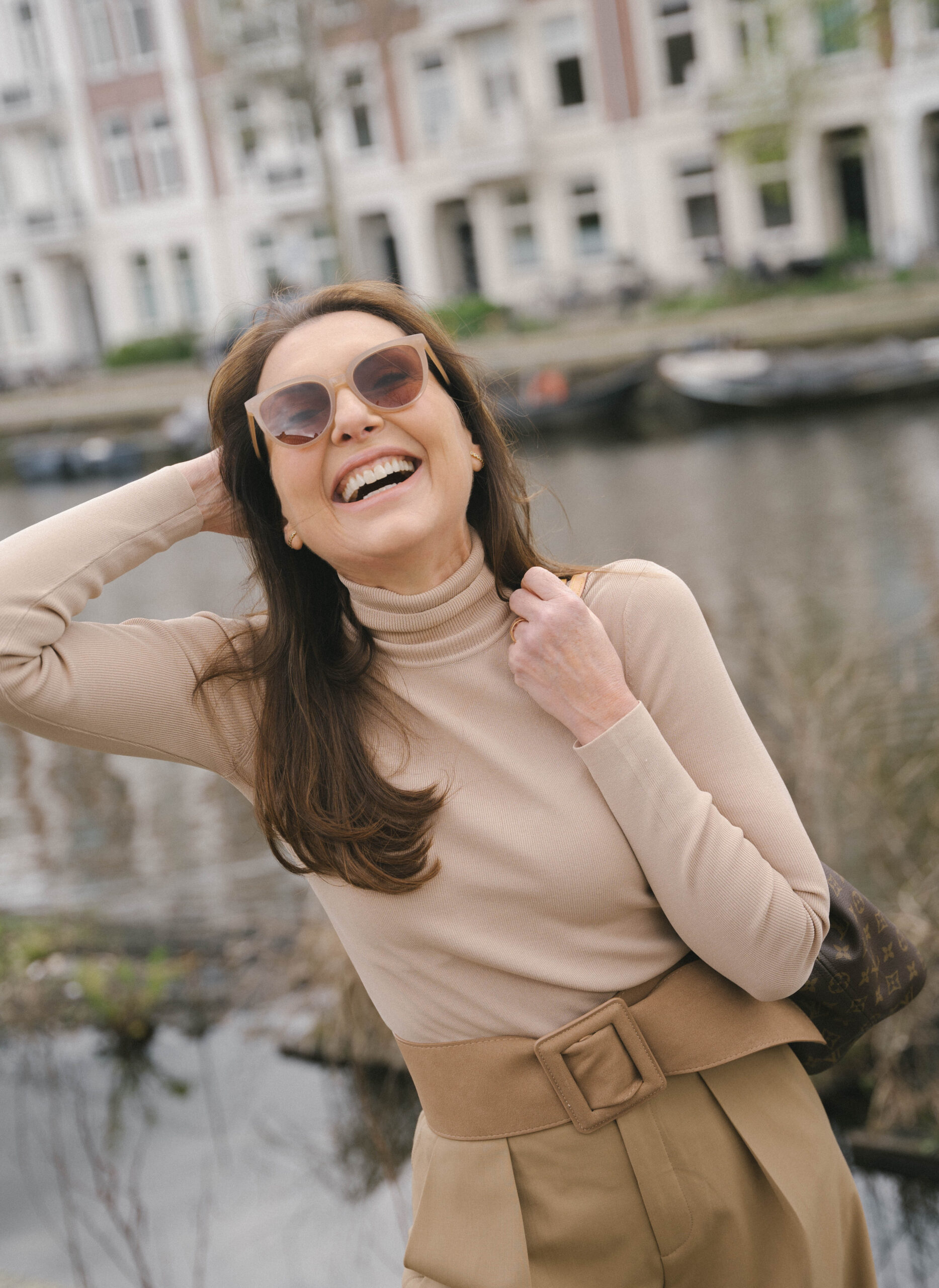 Vrouw met een geel t-shirt aan en glimlachend.