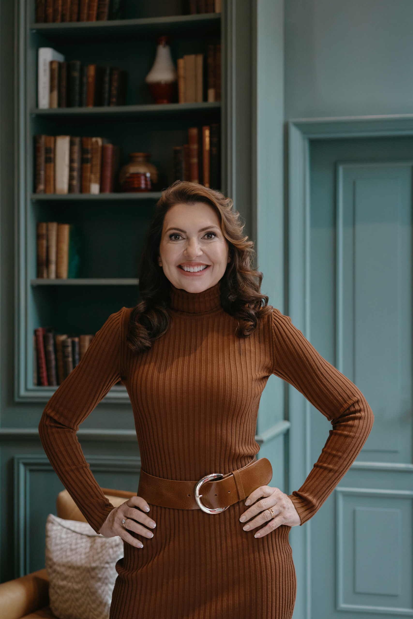 Een zelfverzekerde vrouw met zwart haar die de overhemd van haar vriend aan heeft