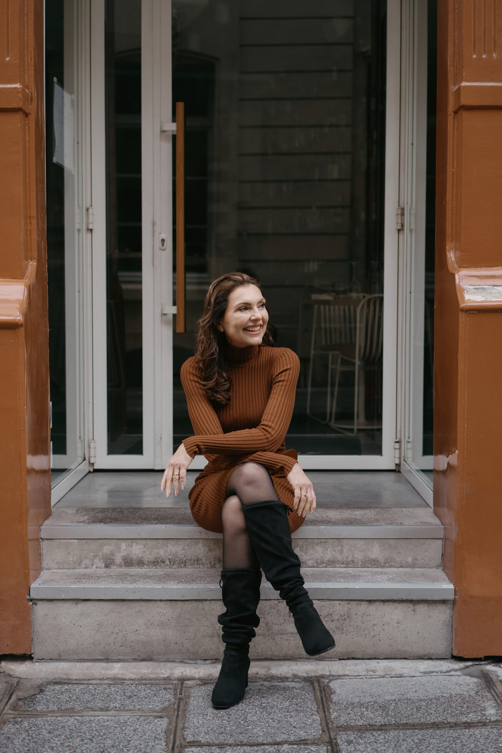 Marjena in een witte blouse, serieus kijkend zittend opzij.
