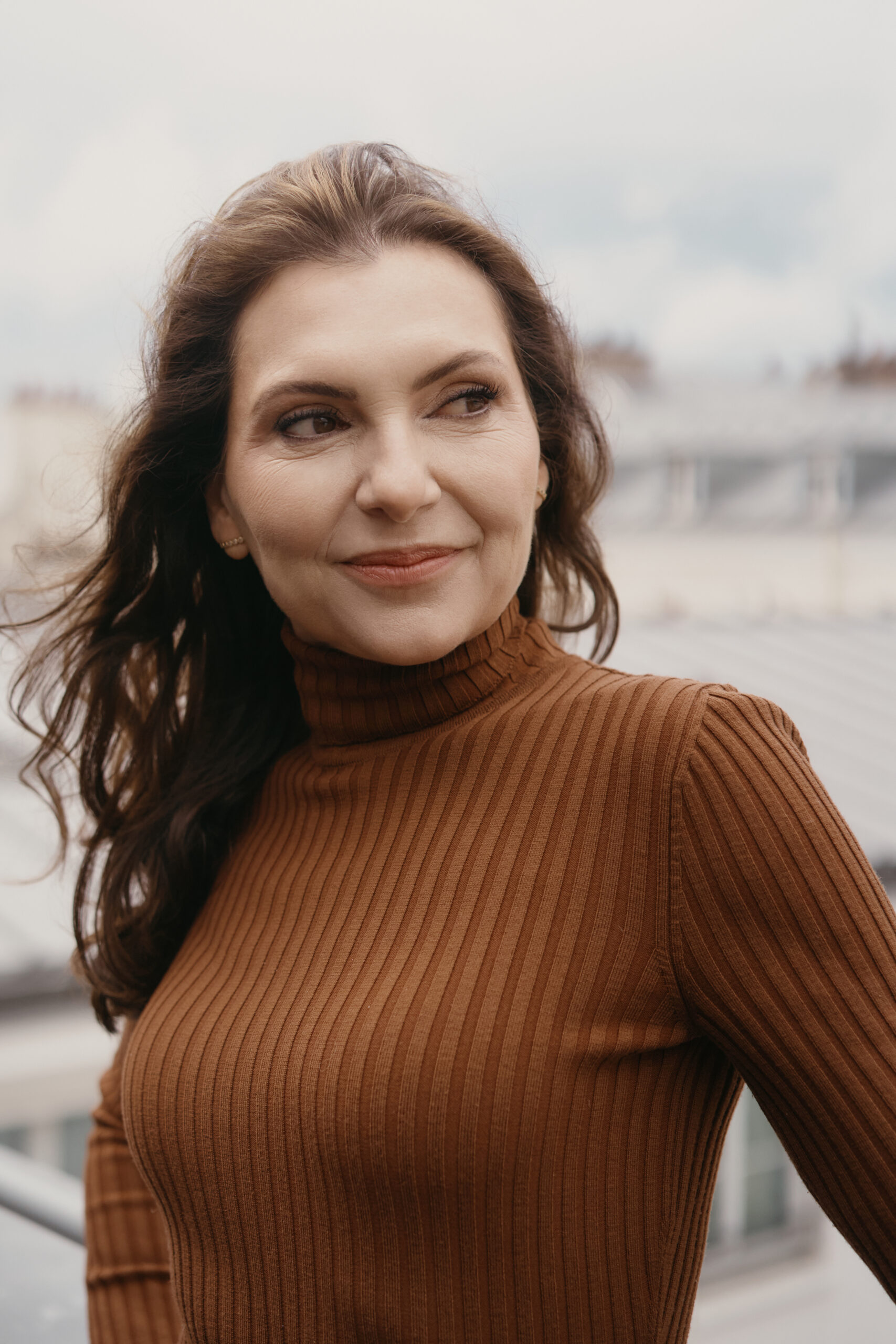 Marjena achter haar laptop, lachend kijkend in de camera.