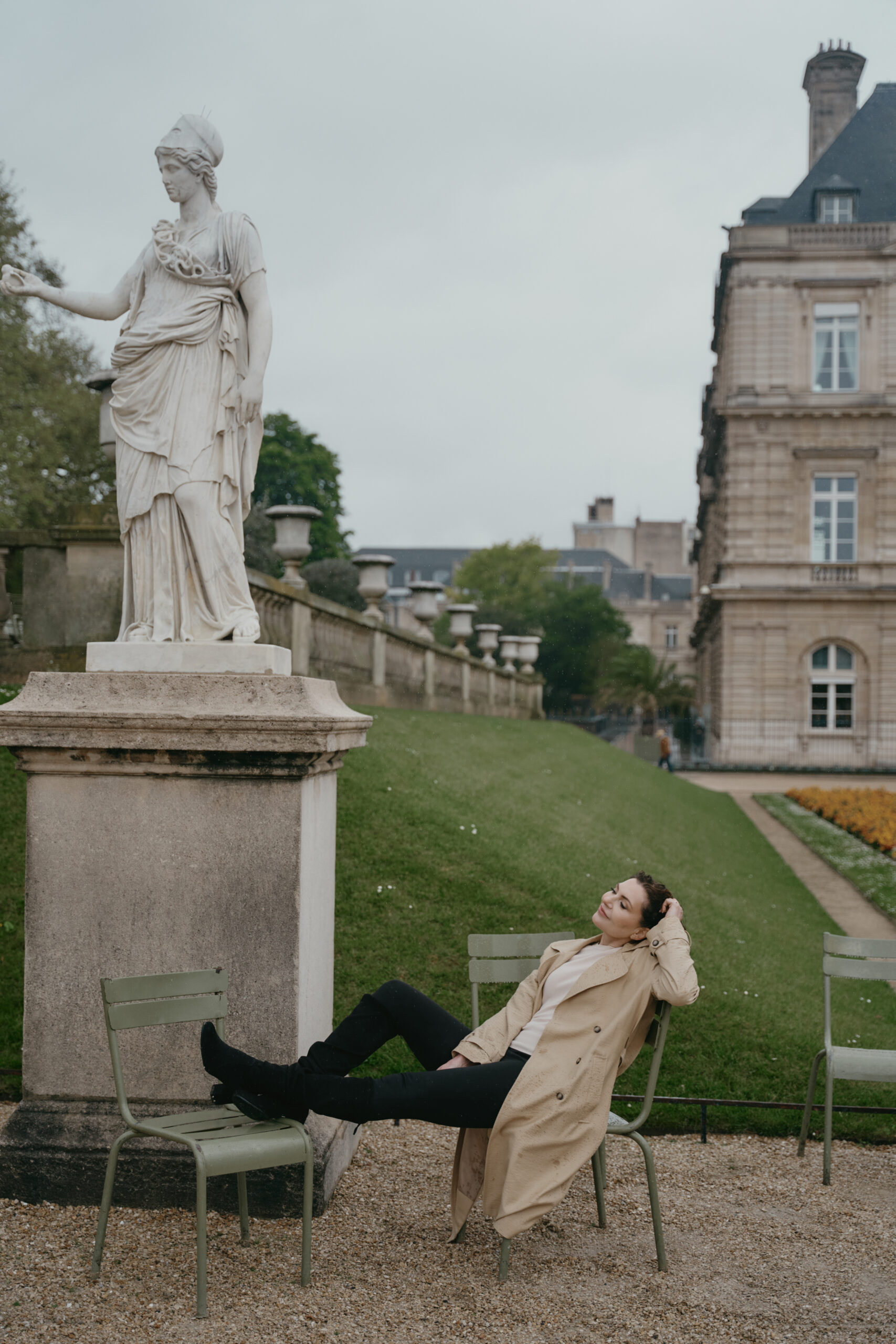 Jonge vrouw in een winterlandschap, close up, lachend kijkend in de camera. Ze heeft een rode muts op.