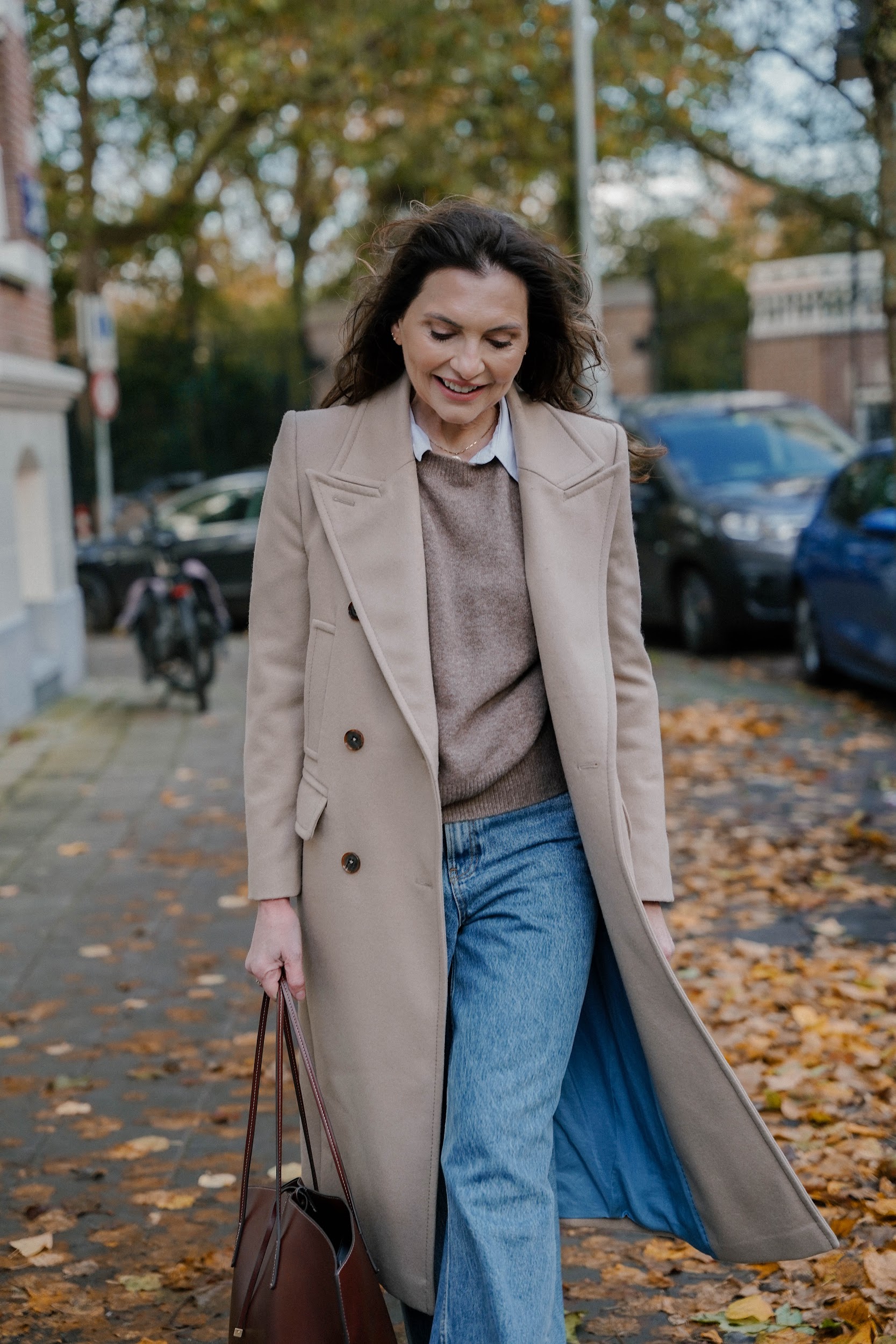 Marjena in een herfstjas lopend over straat