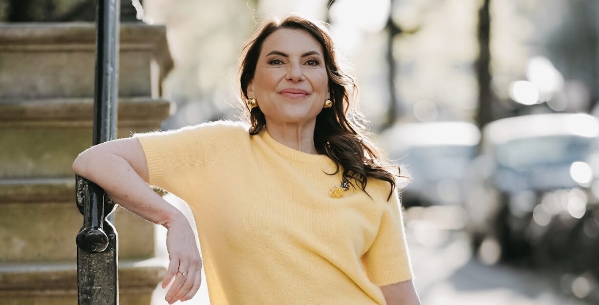 Marjena in een zomerse gele trui en witte broek