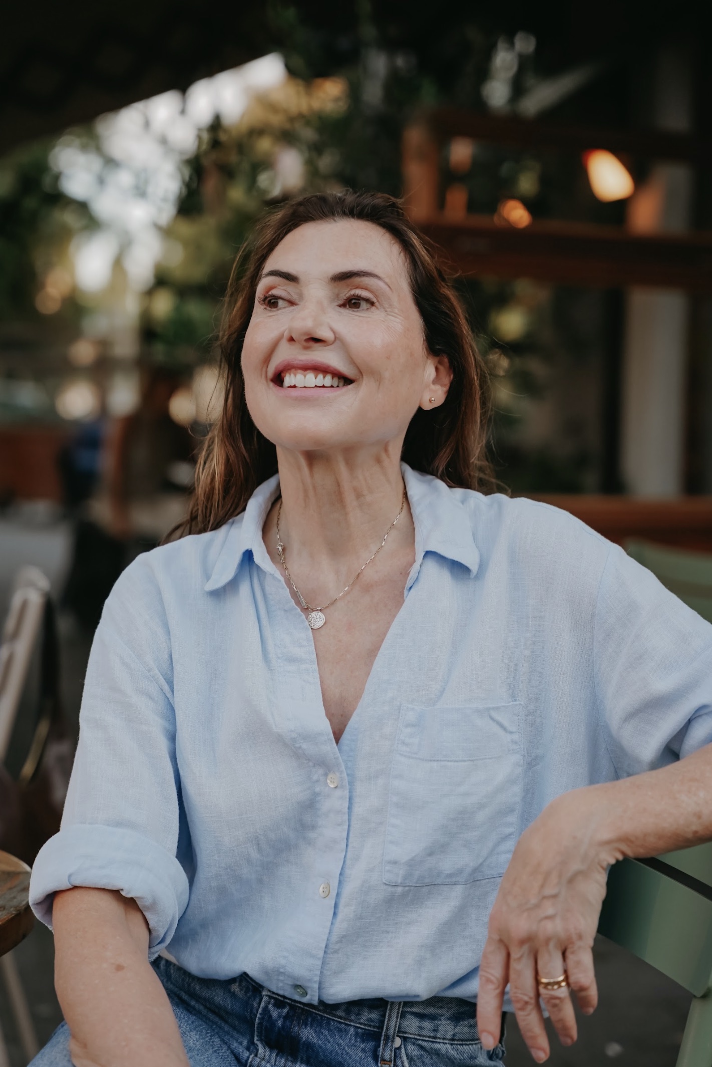 Marjena op een stoel met een blauw overhemd aan