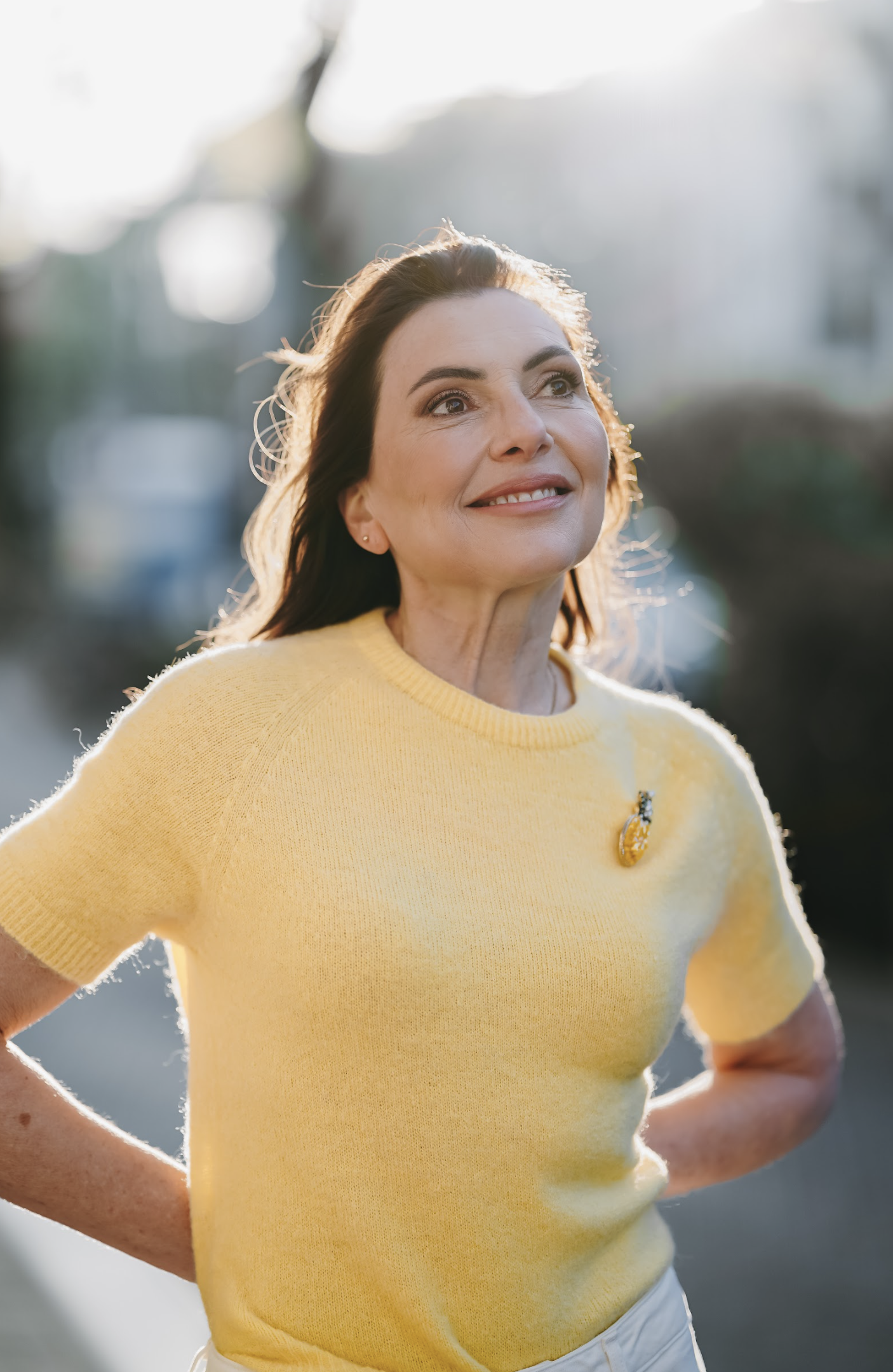 Marjena met een gele trui en etenslessen broche