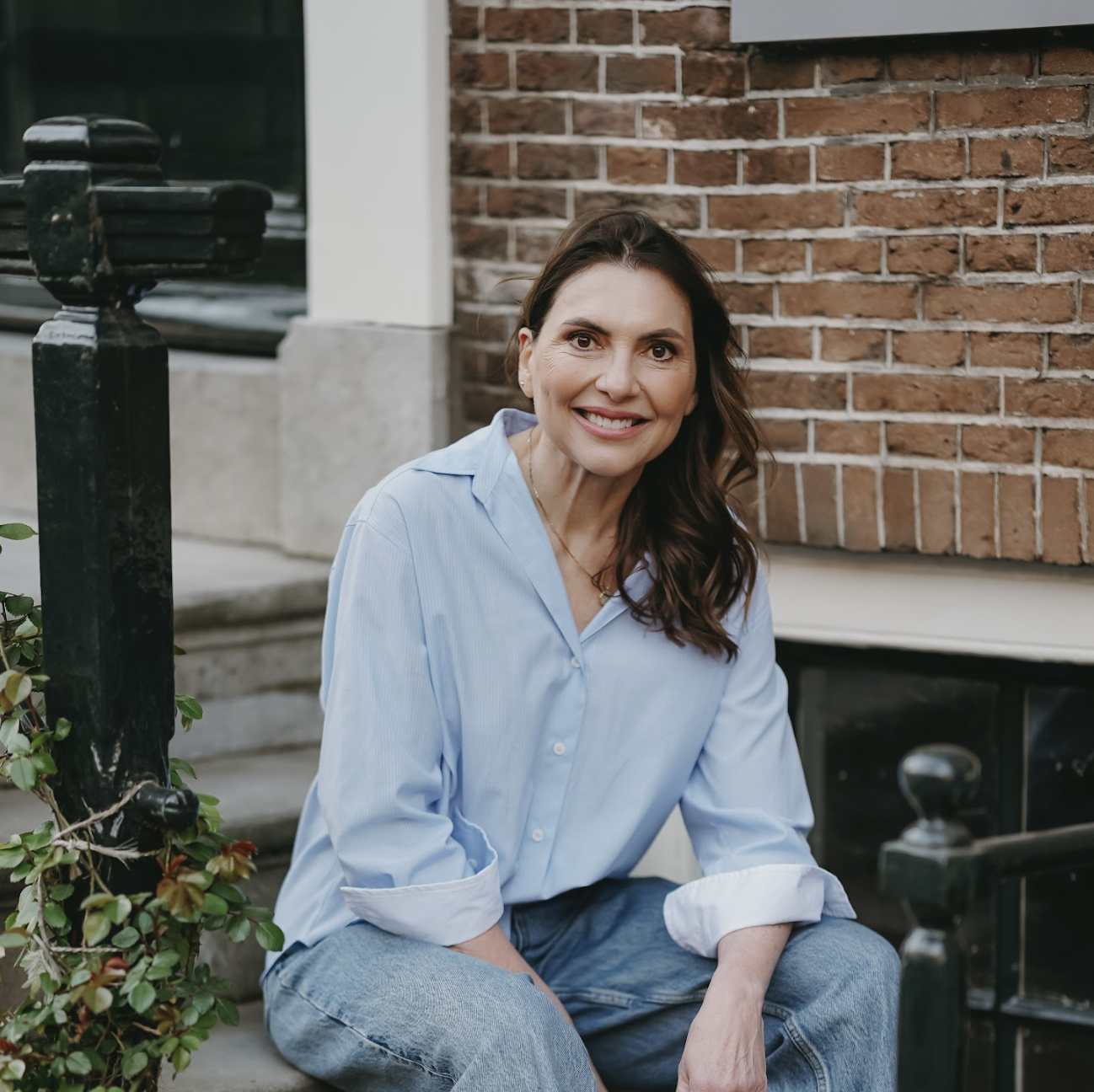 Marjena zitten op een trap bij een grachtenhuis