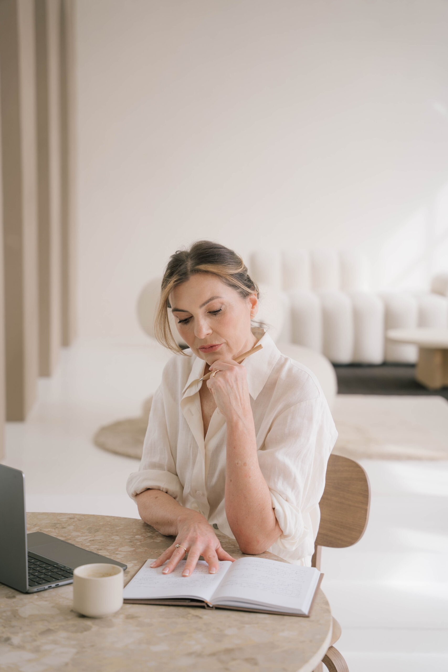 Marjena lachend in een bruine broek met witte blouse, kijken langs de camera