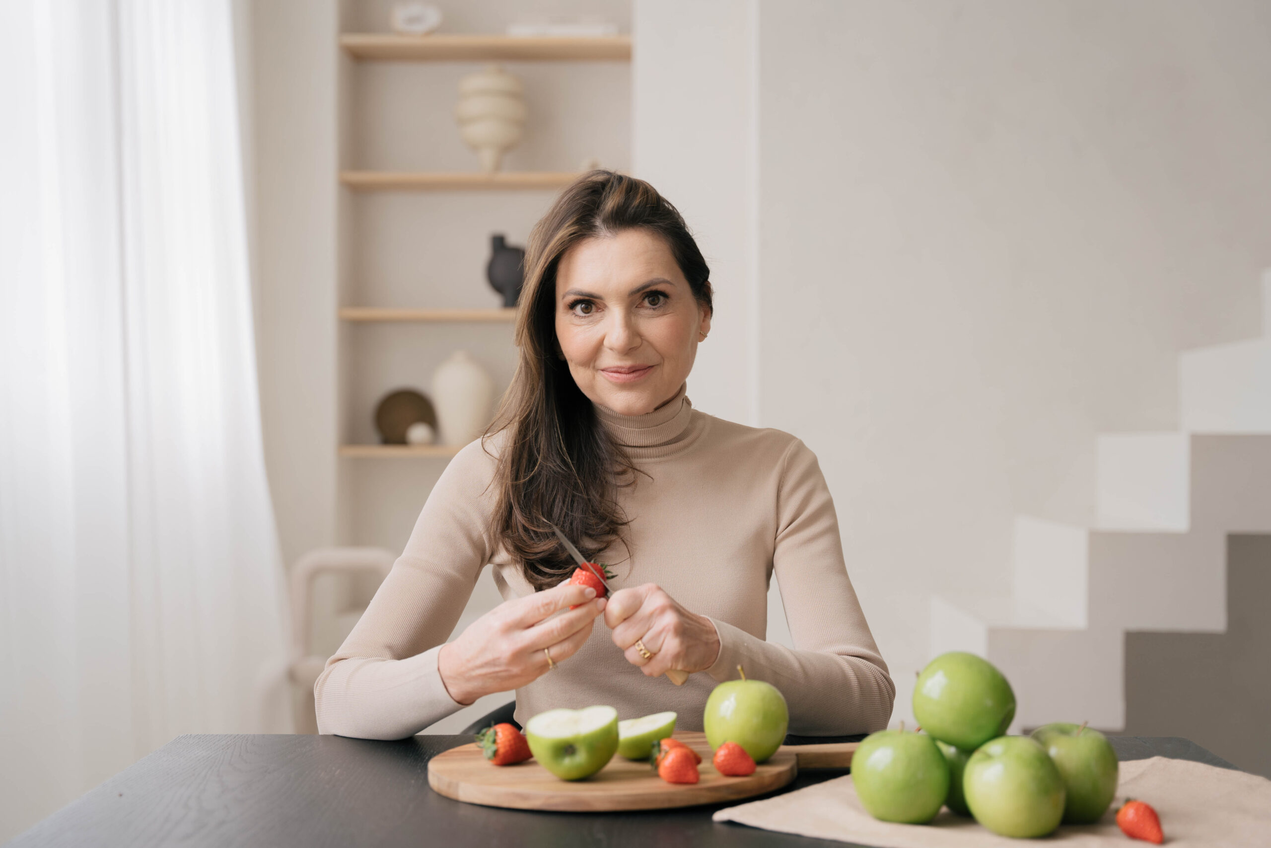 Marjena die een kop thee drinkt zittend aan de tafel